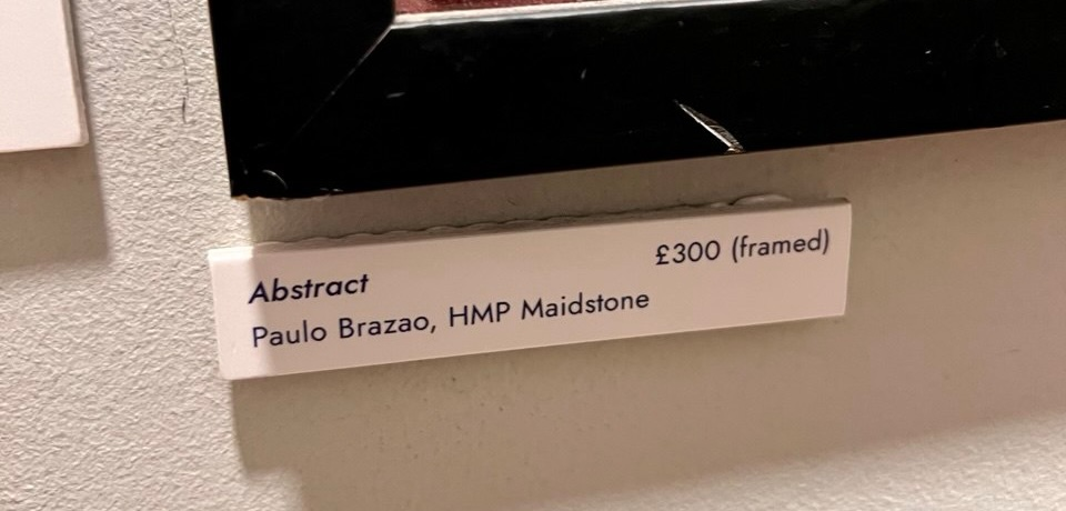 A small label with a price tag beside an artwork on a café wall